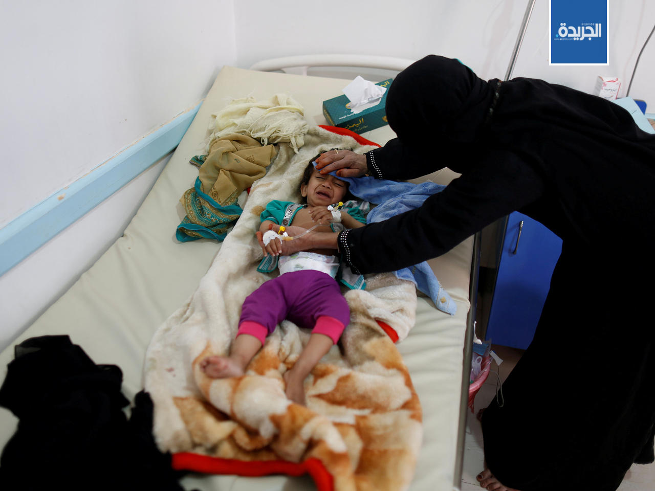 امرأة مع ابنها في مركز لعلاج الكوليرا في صنعاء