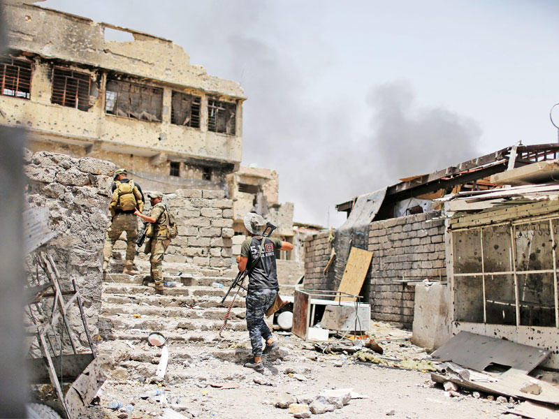 جنود عراقيون خلال عمليات تطهير الموصل أمس (رويترز)