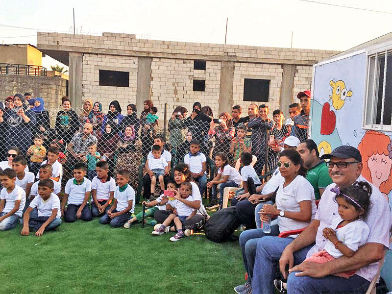 فارعة السقاف وجمال سليمان مع مجموعة من الأطفال في مخيم الفاعور