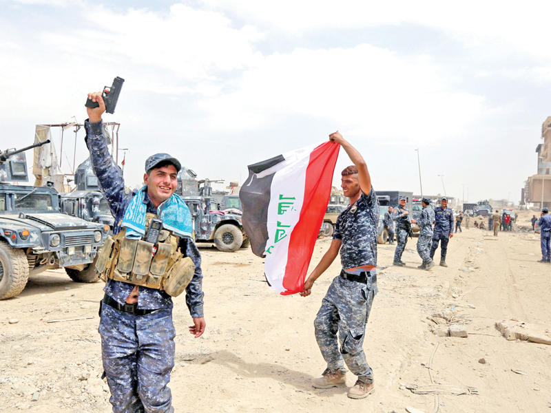 عناصر من الجيش العراقي تحتفل بالنصر في الموصل القديمة أمس             (رويترز)