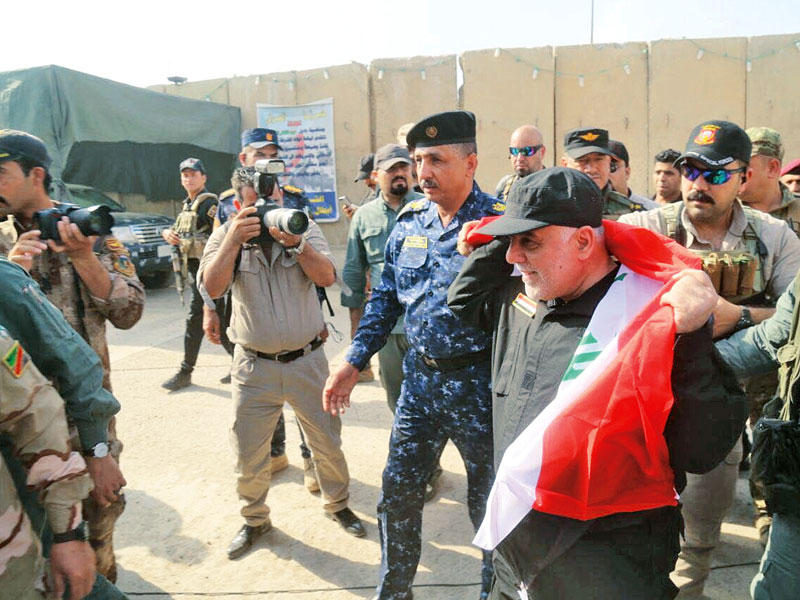 العبادي حاملاً العلم العراقي في الموصل اليوم   