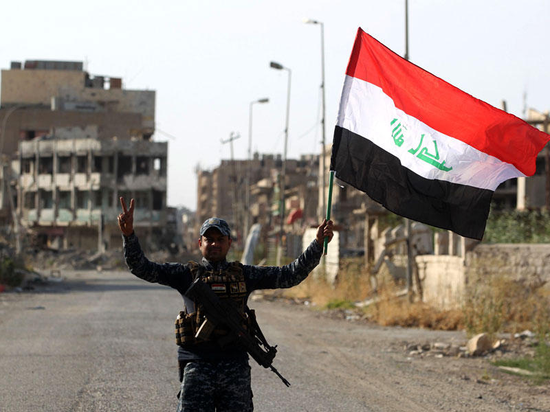 جندي عراقي يحتفل بالنصر في الموصل أمس