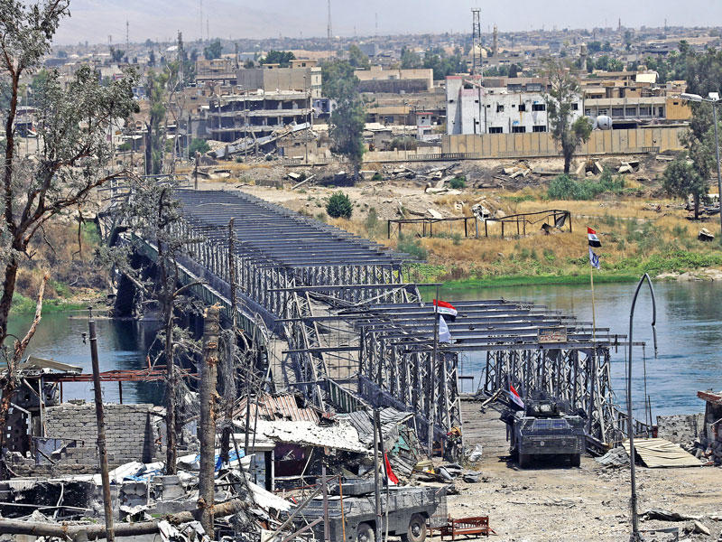 أحد الجسور القديمة على نهر دجلة الذي يقسم مدينة الموصل كما بدا أمس          (رويترز)