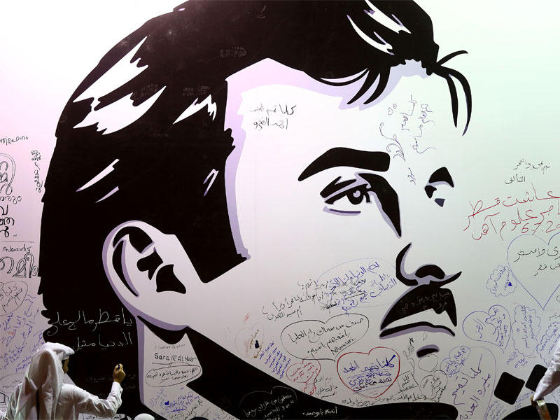 يكتب القطريون تعليقات على جدار يحمل صورة لأمير قطر الشيخ تميم بن حمد آل ثاني
