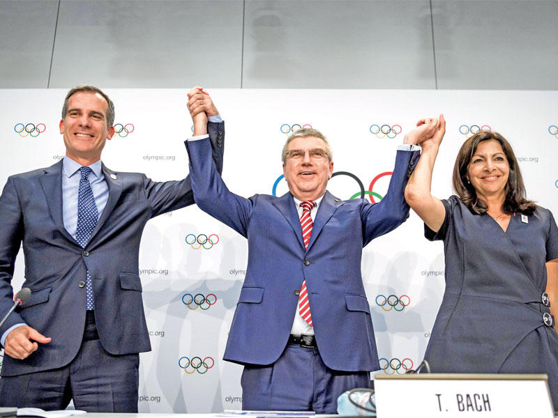 توماس باخ يتوسط آن هيدالغو عمدة باريس وايريك جارسيتي عمدة لوس أنجلس