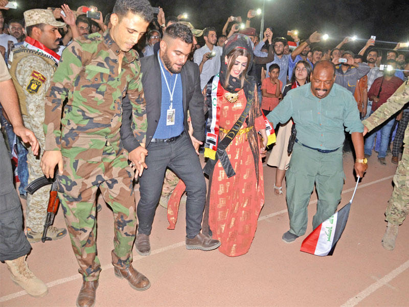 عراقيون يرقصون الدبكة في بغداد احتفالا بتحرير الموصل مساء الأول (رويترز)