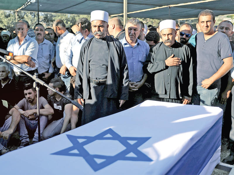 دروز في بلدة حرفيش خلال تشييع احد الشرطيين الإسرائيليين الدرزيين اللذين قتلا في الهجوم بمحيط الحرم القدسي  أمس      (أ ف ب) 