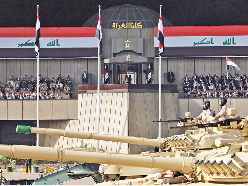 دبابات الجيش العراقي تمر أمام العبادي وأركان الدولة العراقية خلال استعراض عسكري في بغداد بمناسبة تحرير الموصل أمس (رويترز)