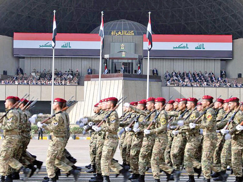 جنود عراقيون يمرون أمام العبادي ومسؤولي الدولة في المنطقة  الخضراء ببغداد  اليوم (رويترز)