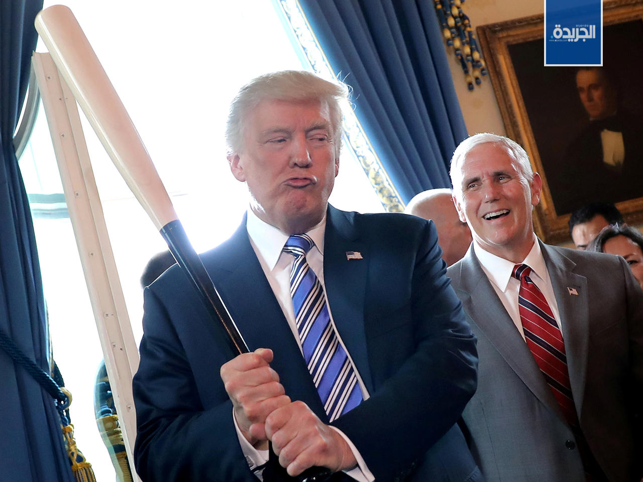 ترامب يمازح فريقه ونائبه مايك بينس ملوحة بمضرب البيسبول خلال حفل عرض منتج  في البيت الابيض بواشنطن.