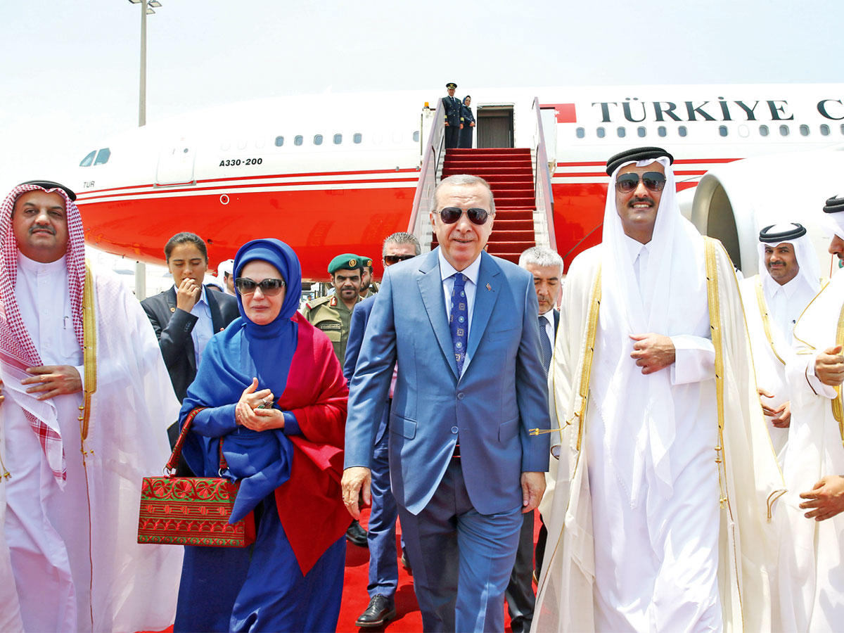 أمير قطر مستقبلاً إردوغان وحرمه في مطار الدوحة (ا ف ب)