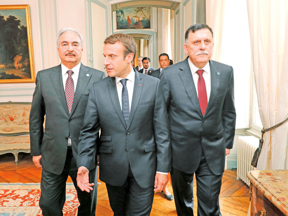 ماكرون متوسطا السراج وحفتر في الإليزيه أمس (أ ف ب)