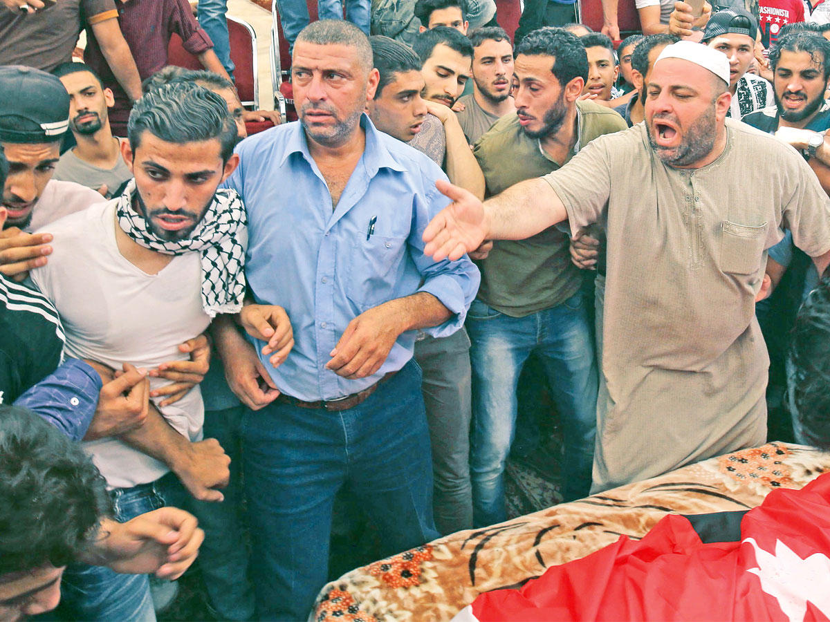 والد الشاب الأردني (يمين) الذي قتل على يد حارس السفارة الإسرائيلية خلال تشييعه في عمّان (أ ف ب)