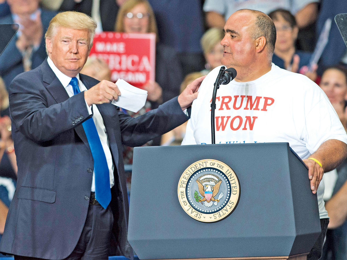 ترامب يستدعي أحد أنصاره إلى المنصة في يونغستون أمس الأول (أ ف ب)