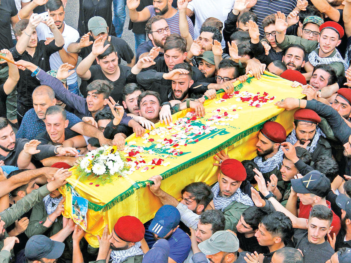 مناصرون لحزب الله في ضاحية بيروت الجنوبية أمس الأول خلال تشييع أحد قتلاه الذين سقطوا في عرسالt (أ ف ب)