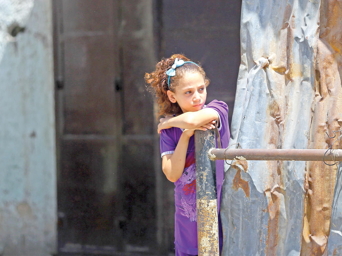 فتاة فلسطينية تنتظر مرور تظاهرة متضامنة مع الاقصى في غزة أمس الأول (أ ف ب)