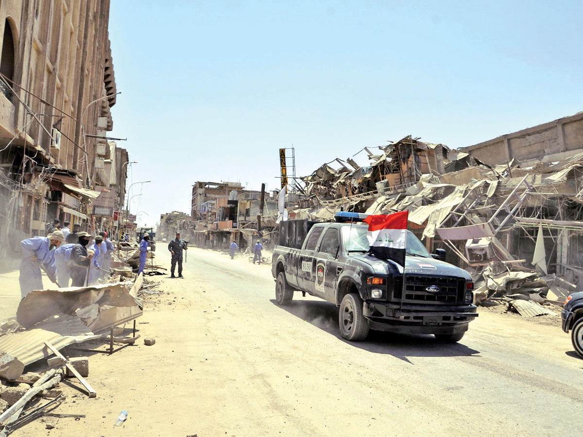 عمال يزيلون الركام من شوارع الموصل أمس (إي بي أيه)