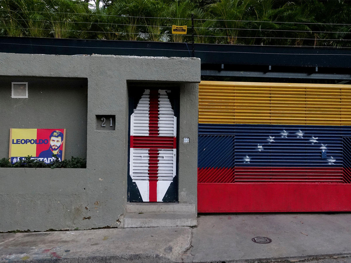  لافتة تصور زعيم المعارضة الفنزويلية ليوبولدو لوبيز خارج منزل في كاراكاس