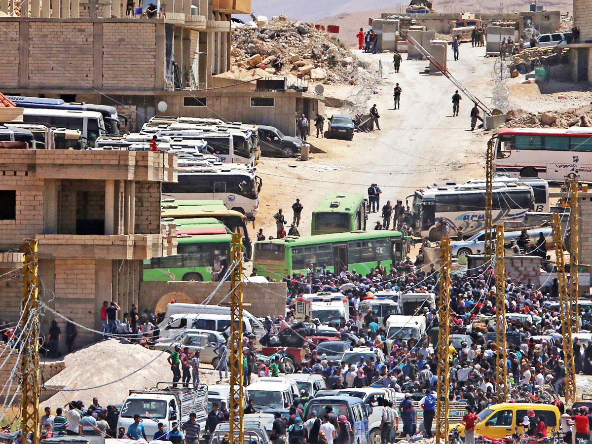 سوريون يستعدون أمس لمغادرة وادي حميد في جرود عرسال شمال شرق لبنان باتجاه محافظة إدلب السورية   (أ ف ب)