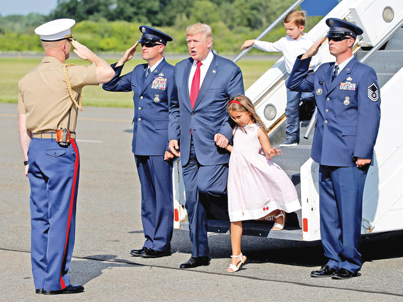 ترامب وحفيداه في مطار مورستاون بولاية نيوجيرسي أمس الأول (رويترز)