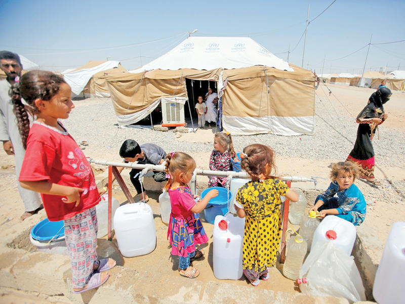 أطفال نازحون يتزودون بالماء في مخيم بالسليمانية  اليوم (رويترز) 