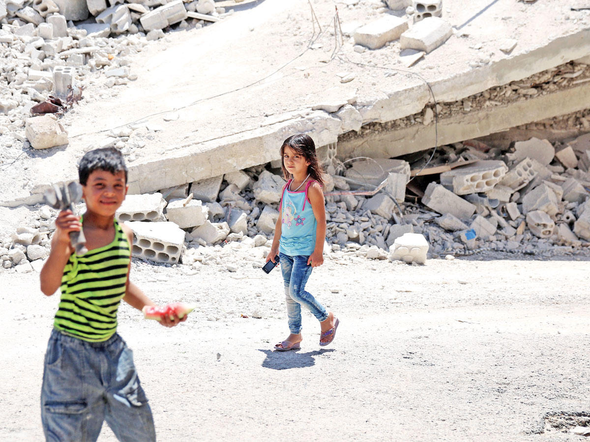 صبي يحمل بقايا قذيفة في درعا الجنوبية أمس الأول (رويترز)