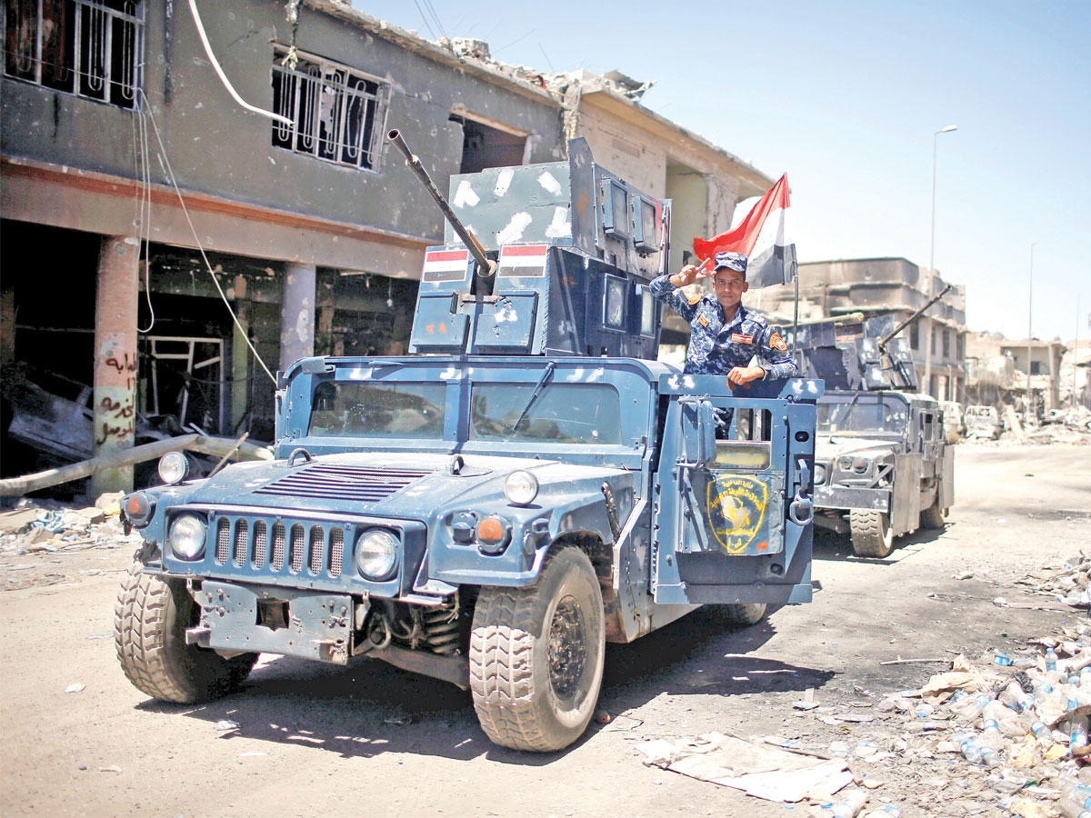 عناصر من قوات الشرطة العراقية تمشط شوارع مدينة الموصل القديمة أمس   (رويترز)