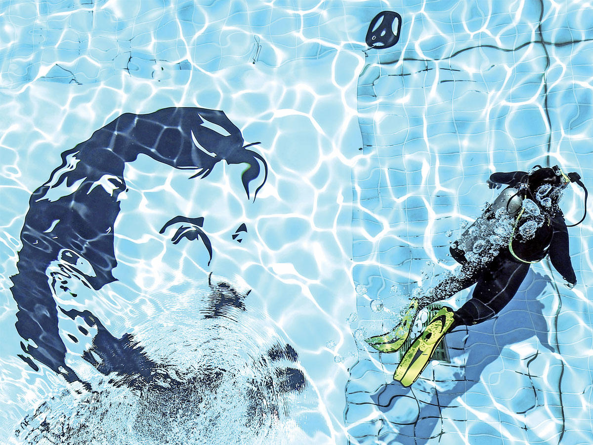 عنصر في قوة الأمن الداخلي القطرية «لخويا» يوقّع على جدارية للأمير تميم بن حمد في مغطس سباحة بجامعة قطر يوم الخميس    (أ ف ب)