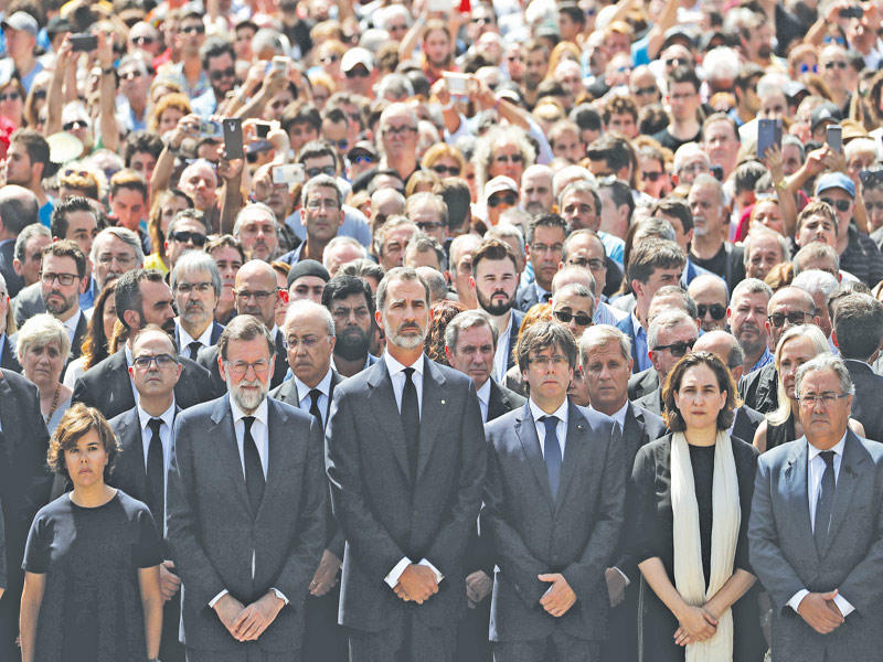 الملك فيليبي وراخوي ورئيس إقليم كاتالونيا كارليس بويغديمونت وعمدة برشلونة إدا كولاو ووزير الداخلية خوان أجناسيو زويدو في دقيقة صمت على أرواح الضحايا في ساحة بلاكا دي كاتالونيا أمس (رويترز)