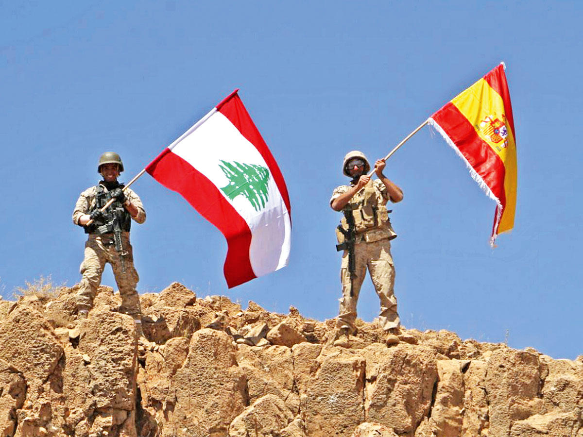 جنديان يرفعان علمي لبنان وإسبانيا على جبل مخايرم في رأس بعلبك أمس الأول تضامناً مع ضحايا هجمات برشلونة وكامبرليس ( ف ب)