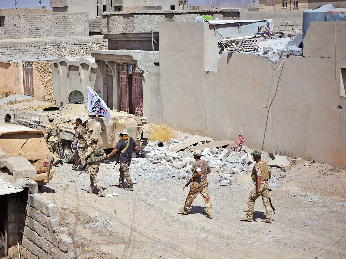 عناصر من الجيش والحشد بحي الجزيرة في تلعفر أمس   (رويترز)