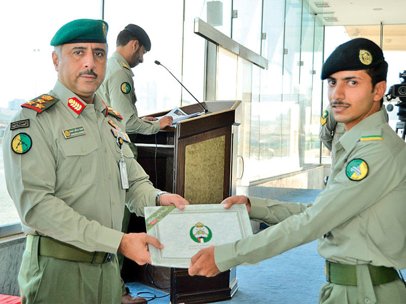 تسليم شهادة التخرج إلى أحد الخريجين