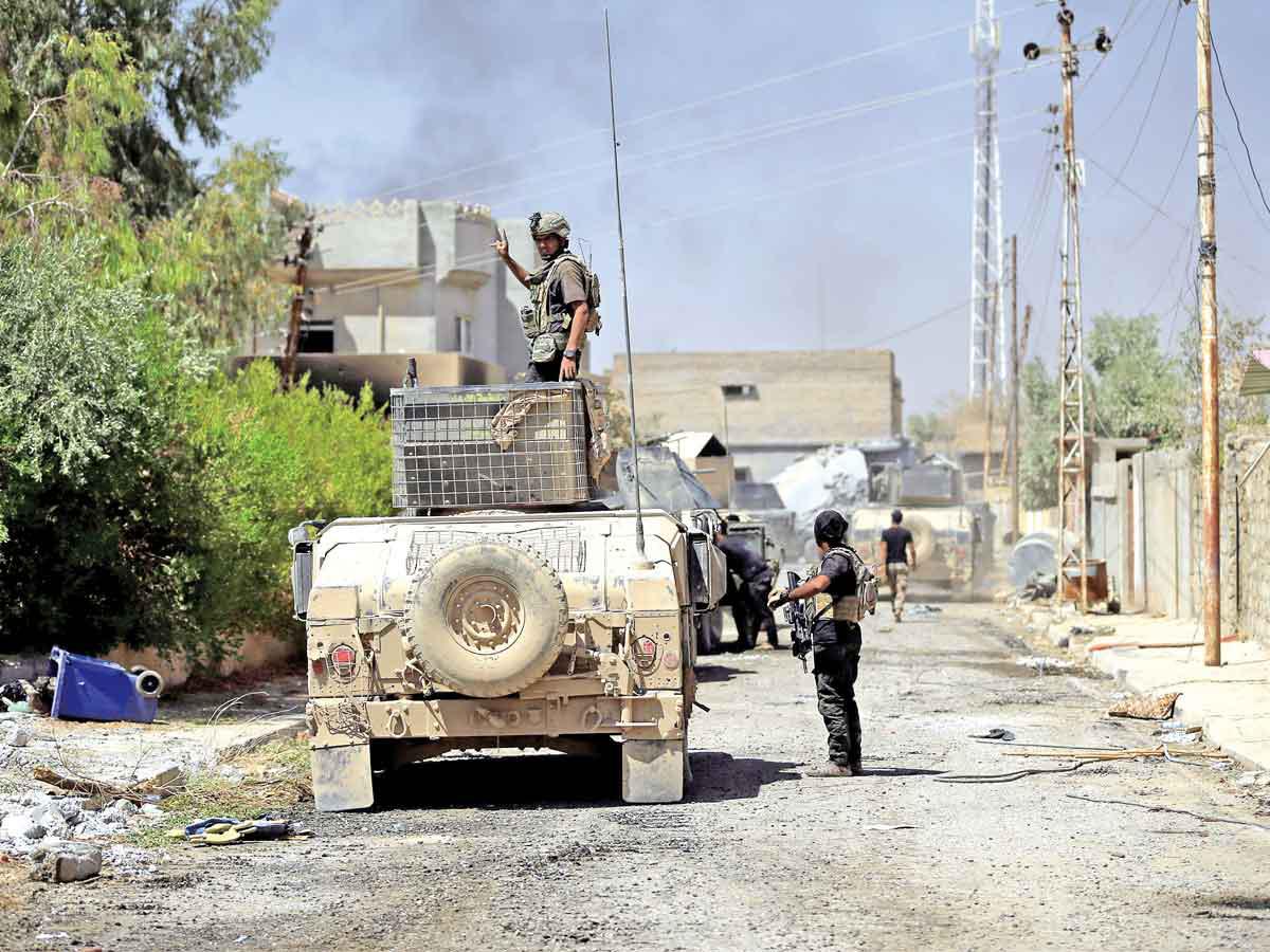 عنصران من القوات العراقية في قضاء تلعفر بعد تحرير عدد من الأحياء (رويترز)