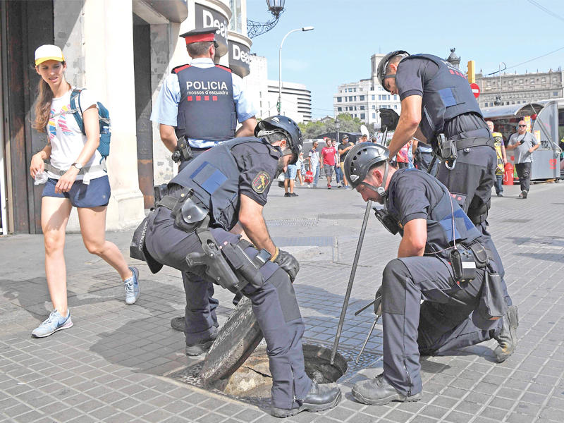 شرطة كاتالونيا الإسبانية تفحص قناة صرف صحي قبل بدأ مسيرة لمكافحة الارهاب في برشلونة أمس      (أ ف ب)