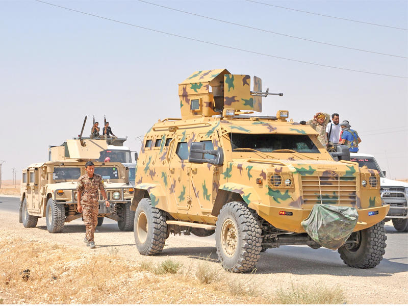 عناصر المجلس العسكري في دير الزور بمدرعاتهم بالقرب من بلدة الشدادي في الحسكة أمس الأول (أ ف ب)