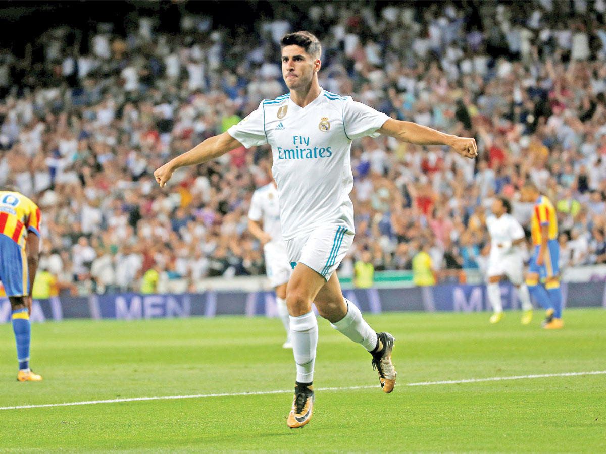 أسينسيو نجم الريال يحتفل بعد إحرازه الهدف الأول في مرمى فالنسيا