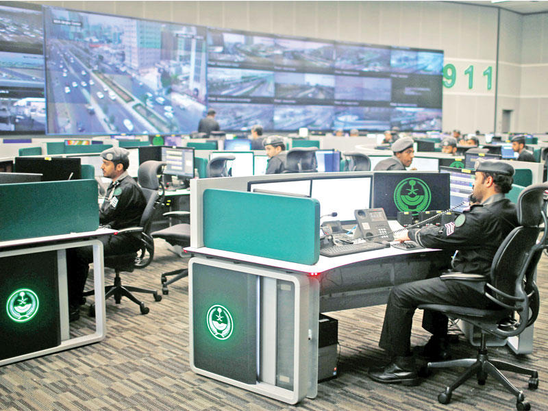 رجال أمن يراقبون عبر شاشات عملاقة بالمركز الوطني للعمليات حركة الحجاج في مكة المكرمة أمسt(رويترز)