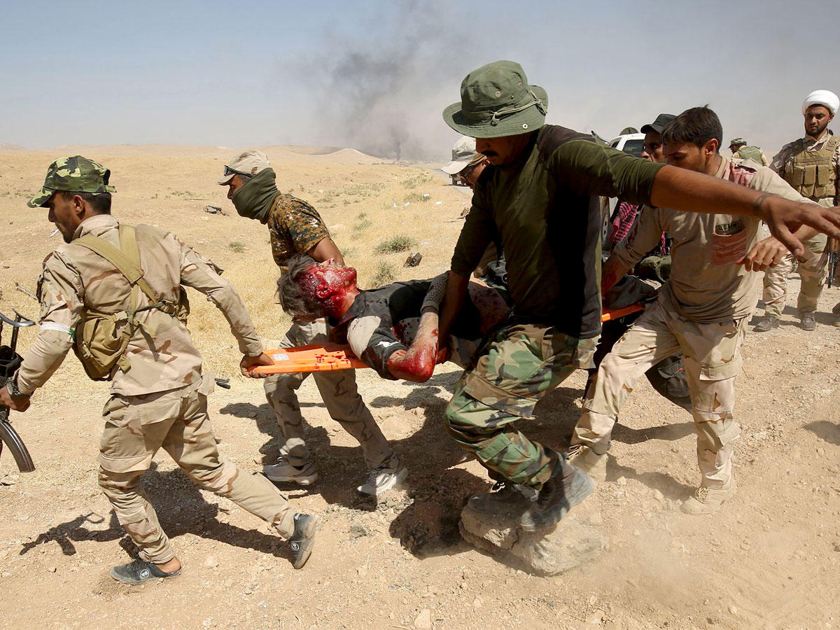 جنود عراقيون يجلون مصاباً في معركة العياضية أمس (أ ف ب) 