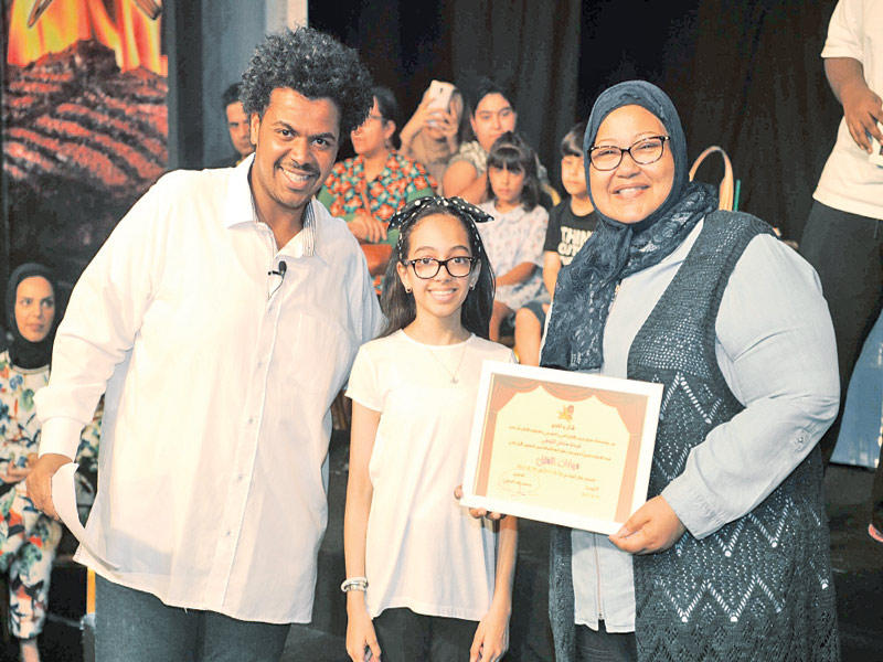 الشراح والحملي مع إحدى خريجات الورشة الفنية 