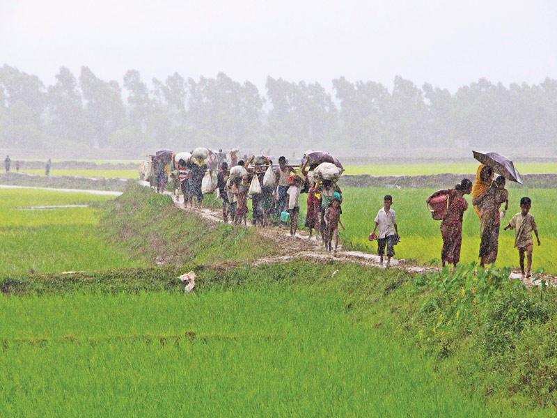 حشد من مسلمي الروهينغا يغادرون راخين باتجاه بنغلادش أمس  (أ ف ب)