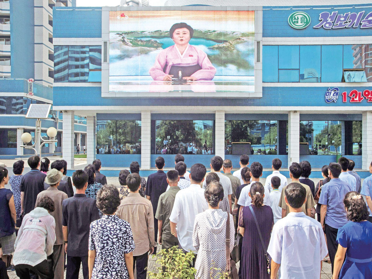 كوريون يتابعون إعلان خبر نجاح التجربة النووية على شاشة عرض وسط بيونغ يانغ أمس   (أ ف ب)