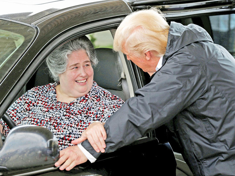 ترامب متحدثاً إلى امراة تنتظر حصة إعاشية في هيوستن بتكساس أمس الأول (رويترز)