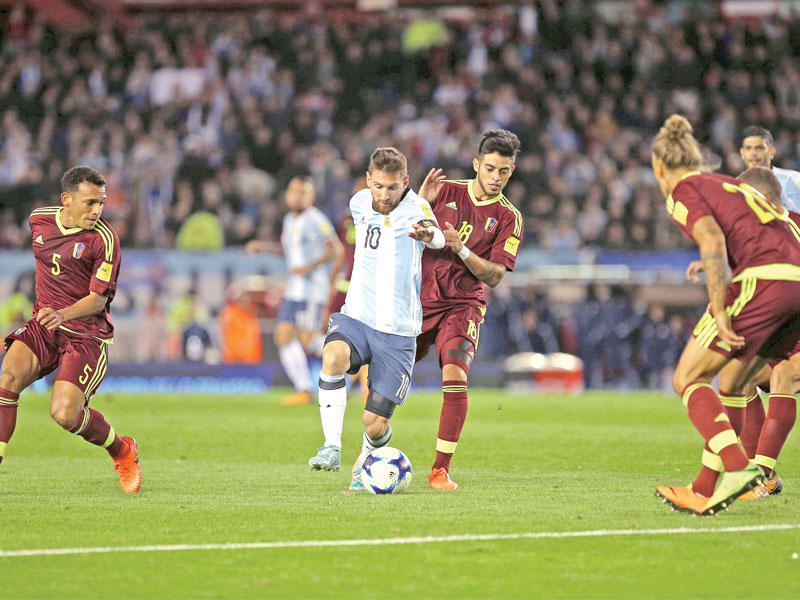 ميسي نجم المنتخب الأرجنتيني محاطاً بلاعبي فنزويلا