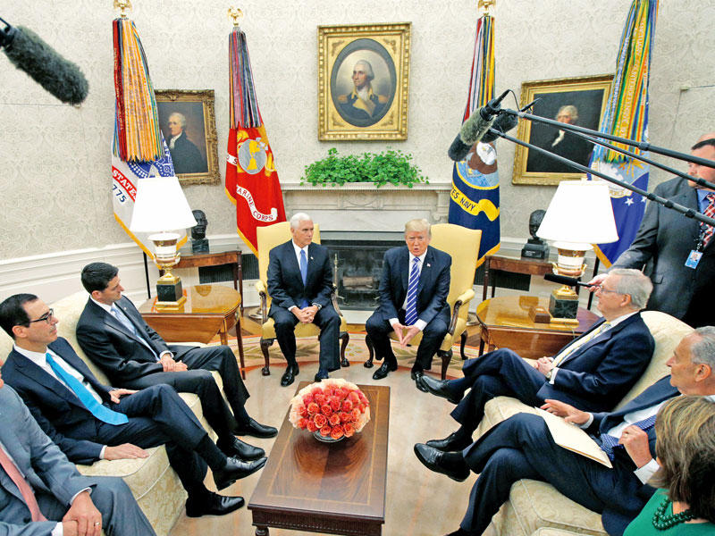 ترامب مستقبلاً زعماء الكونغرس في المكتب البيضاوي بالبيت الأبيض أمس (رويترز)