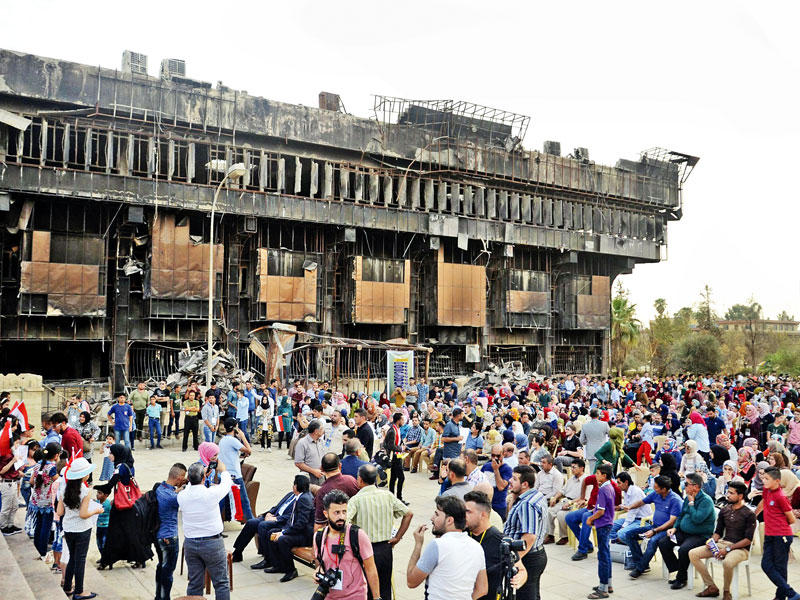 طلبة جامعة الموصل أقاموا معرضاً لبيع الكتب الجامعية عصر أمس الأول على سلالم الجامعة رغم دمارها على يد «داعش» (أي بي أيه)