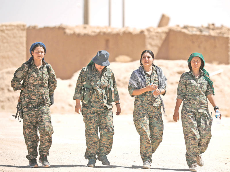 مقاتلات كرديات في قرية أبو فاس بمحافظة الحسكة أمس (رويترز)