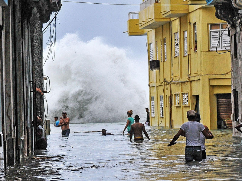 كوبيون في شارع غمرته الفيضانات بهافانا أمسt(أ ف ب)