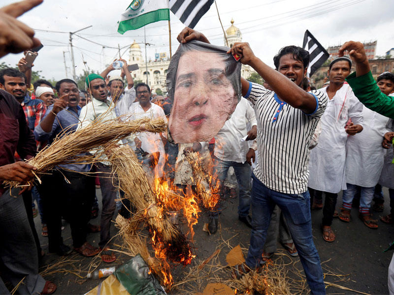 متظاهرون يحرقون صورة رئيسة وزراء بورما احتجاجاً على قمع الروهينغا في مدينة كلاكتا الهندية أمس    (رويترز)