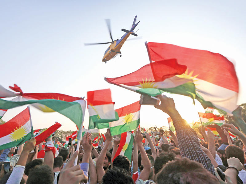 مروحية تحلق فوق أكراد مشاركين في تجمع مؤيد للاستفتاء في أربيل أمس الأول   (أ ف ب)