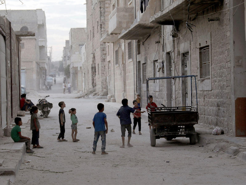 صبية يلعبون في أحد شوارع مدينة الباب أمس الأول (رويترز)
